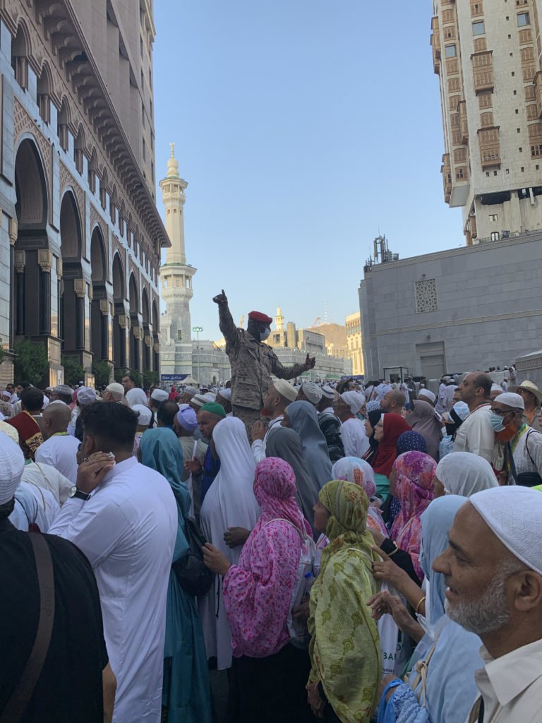 الصورة لـ عمر شاه - الحارس وهو يوجه الحشود قرب الجامع الكبير في مكة